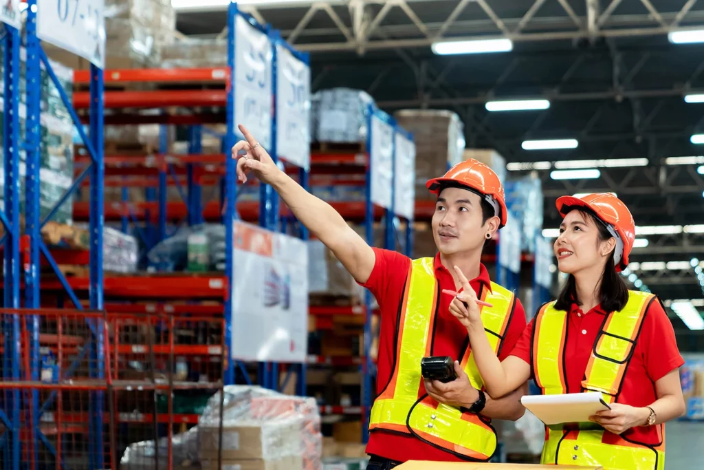Warehouse workers checking storage racks with a scanner and tablet