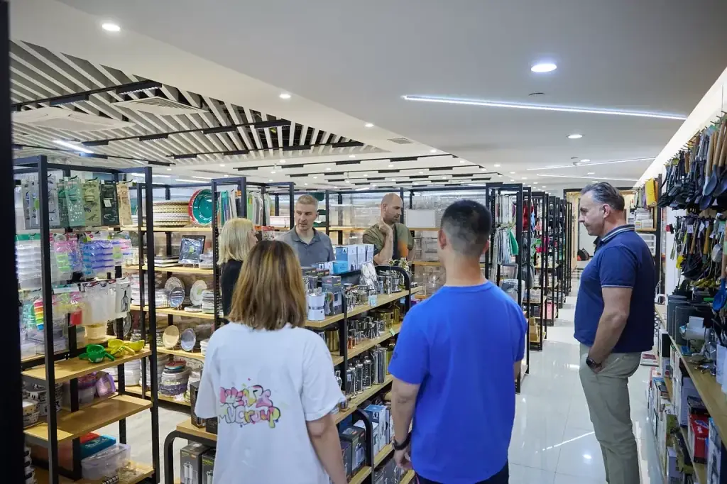International retail buyers reviewing kitchen and household products in a multi-category sourcing showroom